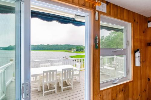 a door leading to a deck with a table and chairs at Spacious 3BR Sunset Island Beach House in Wareham