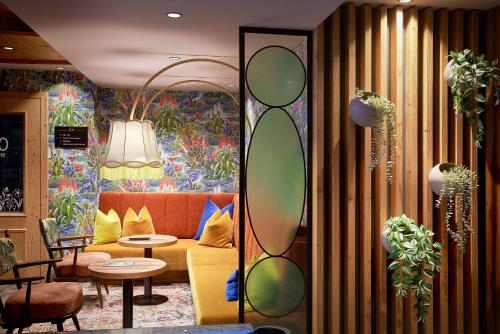 a living room with a couch and a mirror at Hotel Neue Post in Mayrhofen