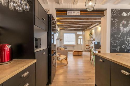 Il comprend une cuisine équipée d'un réfrigérateur noir et un salon. dans l'établissement La Petite Bastille - Maison - Cœur de Montrichard, à Montrichard