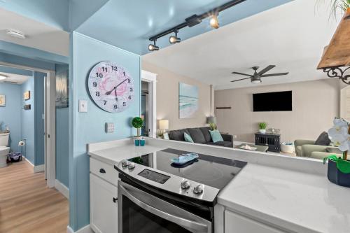 a kitchen and living room with a clock on the wall at Catching Rays 3 Comm Pools Family & Pet friendly in Destin
