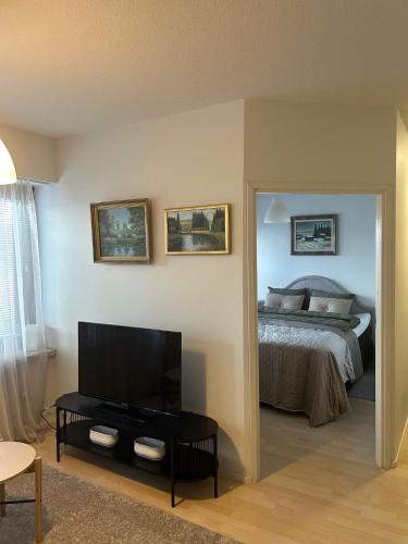 a bedroom with a bed and a flat screen tv at Fredrik Kaksio Haminassa in Hamina