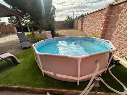 a bath tub sitting on the grass in a yard at Casas Rurales La Picotilla y la Guija in Martiherrero