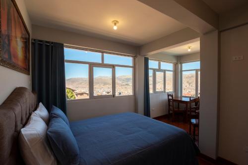 a bedroom with a bed and a large window at Departamento con Vista a la Ciudad in Cusco