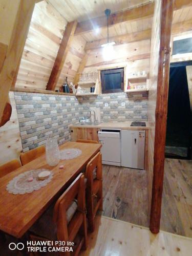 a kitchen with a wooden table in a tiny house at Vila Dajana Zminica in Žabljak