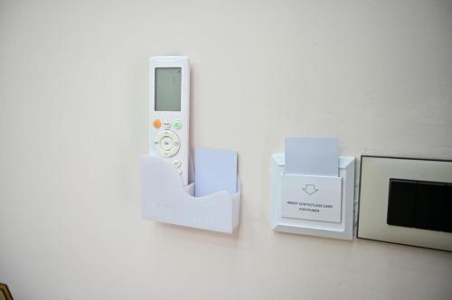a remote control next to a microwave and boxes at Andi Apartments in Durrës