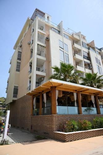 a tall building with a restaurant in front of it at Andi Apartments in Durrës