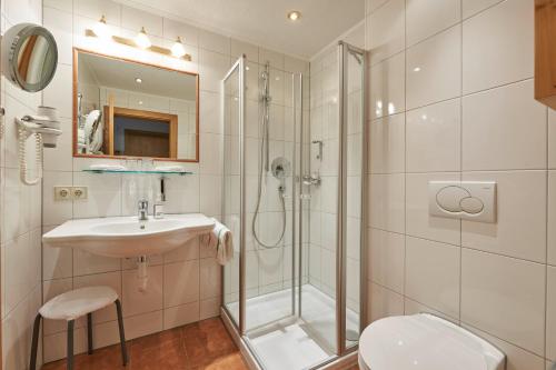 a bathroom with a shower and a sink and a toilet at Après Post Hotel in Stuben am Arlberg