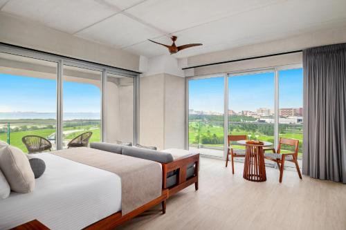 a bedroom with a bed and large windows at Hyatt Vivid Grand Island Cancun-All Inclusive Adults Only in Cancún