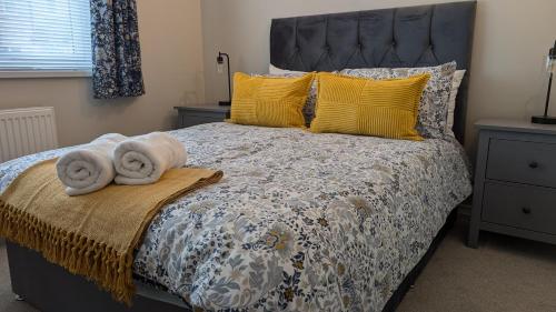 a bedroom with a bed with towels on it at Chy Lowen Private rooms with kitchen, dining room and garden access close to Eden Project & beaches in Saint Blazey