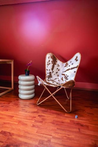 a chair sitting in a room with a red wall at Appartement Tournai Hyper centre in Tournai