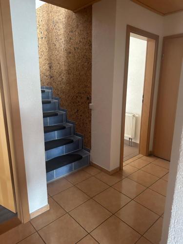 a hallway with a blue staircase in a house at Ferienwohnung Liliane in Rielasingen-Worblingen