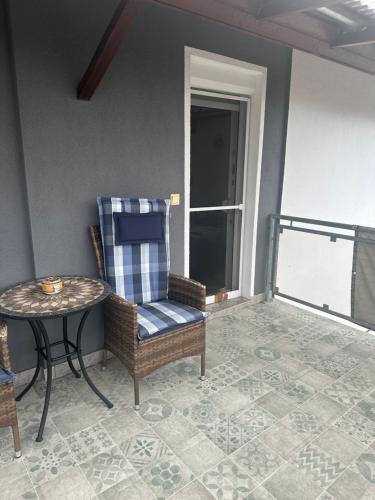 a balcony with a chair and a table and a window at Ferienwohnung Liliane in Rielasingen-Worblingen