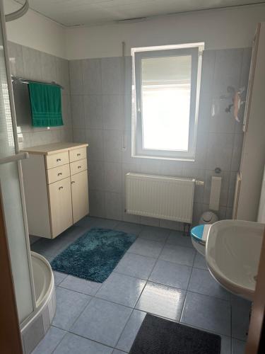 a bathroom with a sink and a tub and a toilet at Ferienwohnung Liliane in Rielasingen-Worblingen