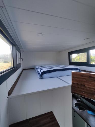 a bed in the middle of a small room at Dikili ZeyTiny House in Dikili