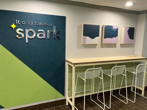 a table and chairs against a wall with a star sign at Spark by Hilton Clarks Summit in Clarks Summit