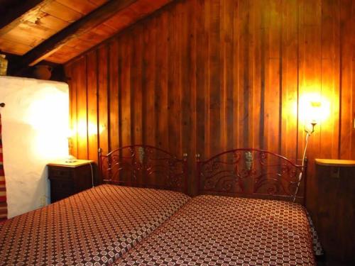 - une chambre avec un lit et un mur en bois dans l'établissement Casa Campo Das Bizarras, à Castro Daire