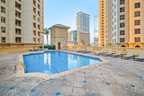 a swimming pool in the middle of a city with buildings at Prime Spacious 5 Plus 1 BR Apt On JBR Beach near Metro ,Walk to The Mall, Dining & Entertainment - By Sunkissed Holiday Homes in Dubai