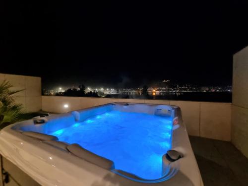 a hot tub on a balcony at night at River Town View - Luxury Apartment with Jacuzzi on Terrace in Viana do Castelo