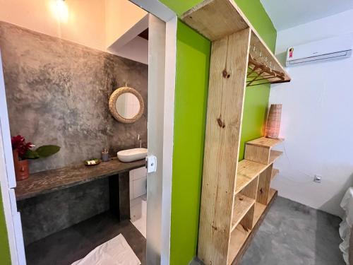 a bathroom with a sink and green walls at Pousada Nascente do Sol in Ilha de Boipeba