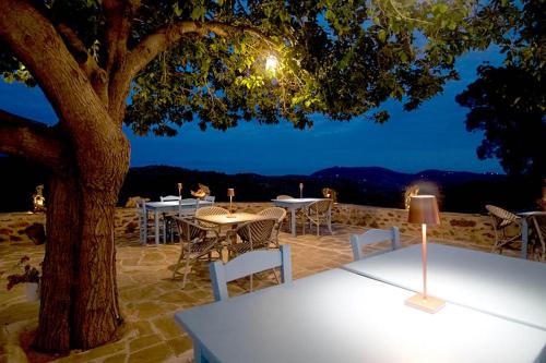 a table and chairs under a tree at night at Petropoulakis Tower in Gythio