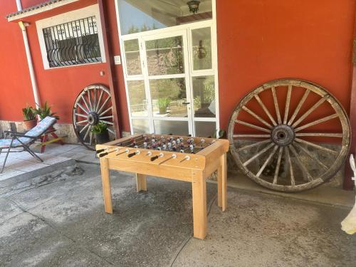 a wooden foosball table next to a large wheel at Casas Rurales La Picotilla y la Guija in Martiherrero