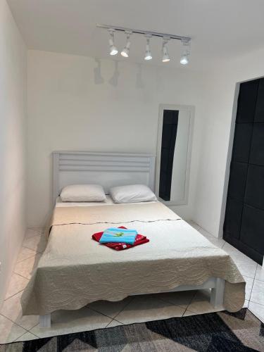 a bedroom with a bed with a blanket on it at Suite 1, Casa Amarela, Segundo Andar in Nova Iguaçu