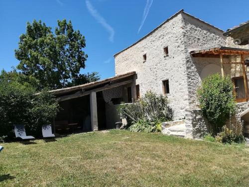 a stone house with a yard in front of it at Maison en éco construction in Piégros-la-Clastre
