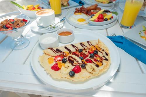 a table with a plate of breakfast food on it at Amsterdam Manor Beach Resort in Palm-Eagle Beach