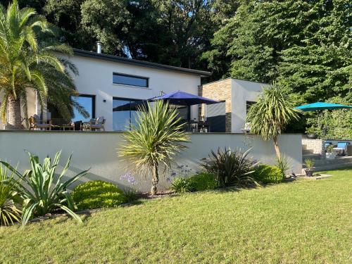 une maison blanche avec une cour plantée de palmiers dans l'établissement Superbe villa panoramic Provence, à Montélimar