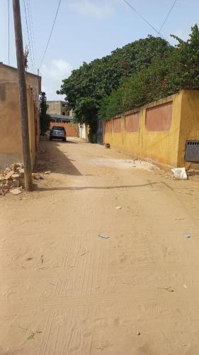 una calle vacía con un edificio amarillo y un coche en Studio tranquille à Saly Niakhniakhal, en Saly Niakh-Niakhal