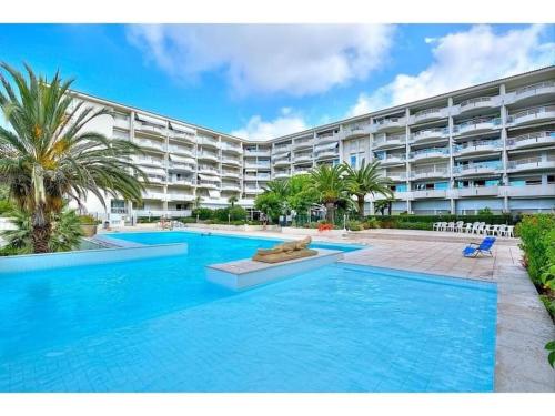 une piscine devant un grand immeuble d'appartements dans l'établissement Appartement terrasse piscine et accès plage, à Antibes
