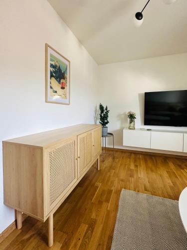 a living room with a large television and a wooden floor at Vyskoč na hory in Nová Lesná