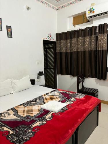 a bedroom with a bed with a red blanket at The Royal Lake View Villa in Udaipur