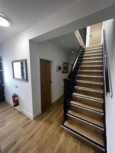 a hallway with a staircase and a door at The Barrington Hotel in New Barnet
