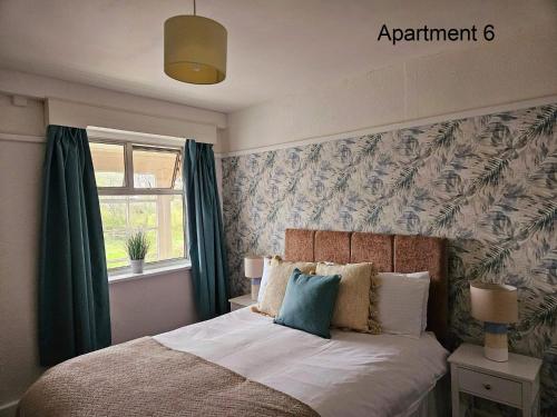 a bedroom with a bed with green curtains at Beach Court Holiday Apartments in Skegness
