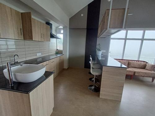 a bathroom with a sink and a kitchen with a counter at Castra villas - Pool Villa in Parunthumpara in Vandiperiyār