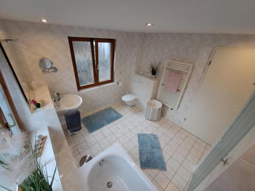 a bathroom with a tub and a sink and a toilet at Familienfreundliche FeWo in Offenburg