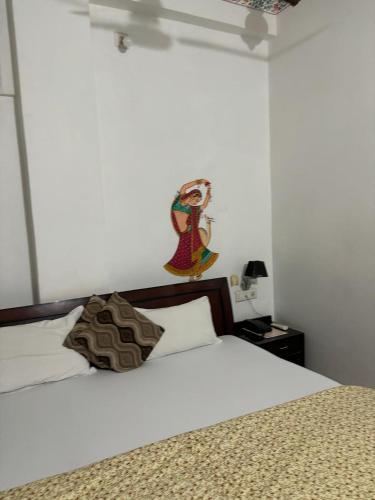 a bedroom with a white bed with a wooden headboard at The Royal Lake View Villa in Udaipur