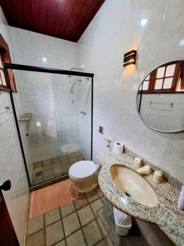 a bathroom with a toilet and a sink and a shower at Casa Rosada seu refúgio na serra in Miguel Pereira