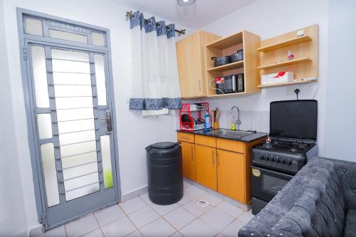 a small kitchen with a stove and a window at Serene studio along Ngong road-Nairobi in Nairobi