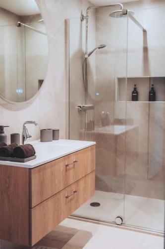 une salle de bain avec une douche avec un lavabo et un miroir dans l'établissement Maison de ville avec parking - calme - Vieux-Lille, à Lille