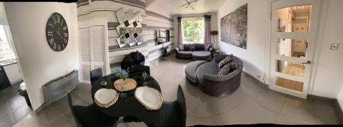a living room with two couches and a table at Edinburgh City Centre & Airport 2 Bedroom Apartment in Edinburgh