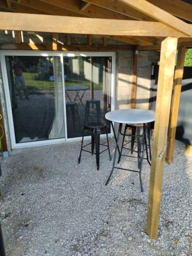 une table et des chaises assises sous un toit en bois dans l'établissement L'évasion de l'ouest, à Dole