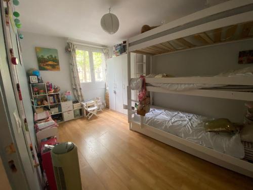 une chambre avec deux lits superposés et un plancher en bois dans l'établissement Appartement Boulogne avec terrasse, à Boulogne-Billancourt