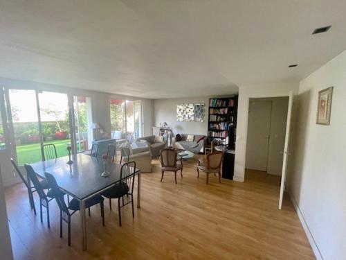 un grand salon avec une table et des chaises dans l'établissement Appartement Boulogne avec terrasse, à Boulogne-Billancourt