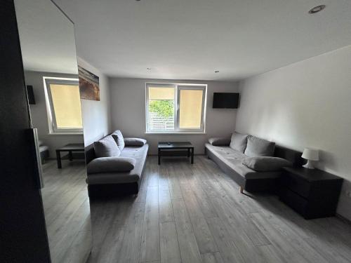 a living room with a couch and two chairs at Pueblo Pokoje in Stegna