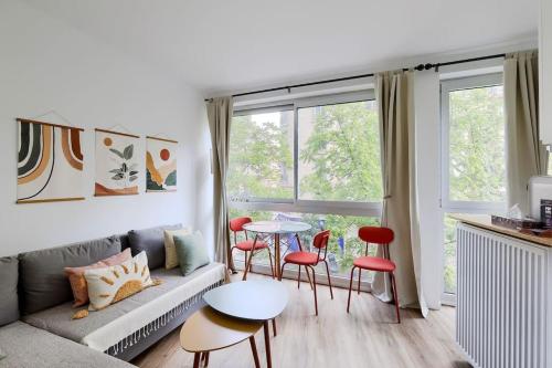 un salon avec un canapé, une table et des chaises dans l'établissement Studio pour 4 personnes, à Paris