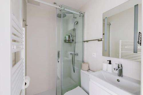une salle de bain blanche avec une douche et un lavabo dans l'établissement Studio pour 4 personnes, à Paris