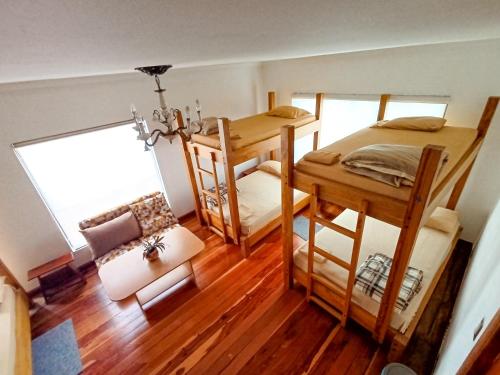 a room with two bunk beds and a couch at Hostal Mochiliers Bed and Breakfast in Cuenca