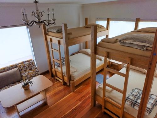 a room with two bunk beds and a couch at Hostal Mochiliers Bed and Breakfast in Cuenca